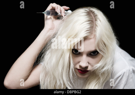 Schöne junge Mädchen in das Bild des bösen Krankenschwester mit Spritze in der hand machen einen Schlag Stockfoto