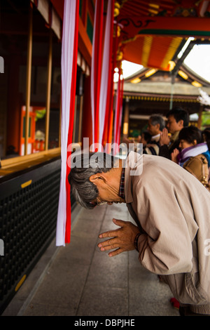 Beten Pilger in der endlosen Red Gates von Kyotos Fushimi Inari Schrein, Kyoto, Japan, Asien Stockfoto