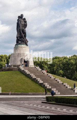 Sowjetisches Kriegsdenkmal, Treptower Park, Berlin. Statue des sowjetischen Soldaten, der Kind und Schwert hält und auf gebrochenem Hakenkreuz trampelt.. Russisches Denkmal Stockfoto