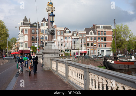 Bürgersteig auf Hogesluis Brücke (Hoge Sluis Brug) und historischen Häusern, Stadt Amsterdam in Holland, Niederlande. Stockfoto