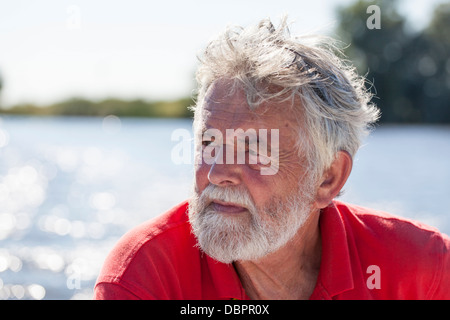 Porträt senior Mann 60-70 mit einem Bart mit Wasser im Hintergrund Stockfoto