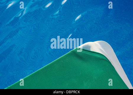 Eine Sonnenliege sitzt neben einem Schwimmbad. Stockfoto