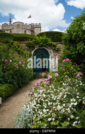 Einen Einblick in Rousham House aus in die bunte ummauerten Garten mit seinen verzierten Tor und floralen Grenzen, Oxfordshire, England Stockfoto