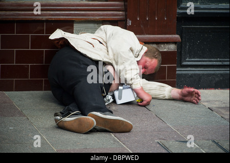 Ein Mann ohnmächtig auf der Straße in Cardiff, UK. Stockfoto