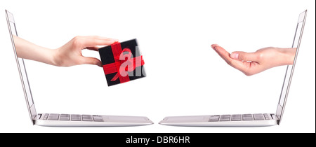 Hand mit einem Geschenk kommen aus einem Bildschirm von einem Laptop-Computer isoliert auf weißem Hintergrund. Stockfoto