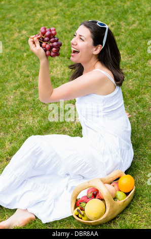 Frau in einem Park mit rustikalen Obstkorb Stockfoto