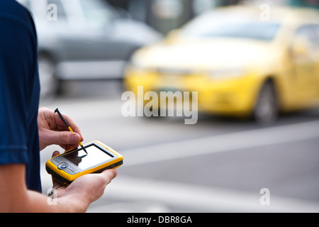 Ein Mann verwendet ein Handheld-GPS-Gerät zu navigieren Stockfoto