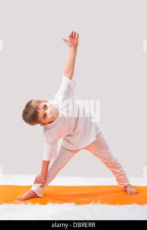 Kinder Yoga. Der kleine Junge übt. Stockfoto