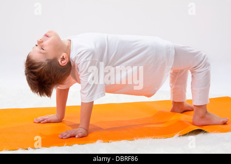 Kinder Yoga. Der kleine Junge übt. Stockfoto