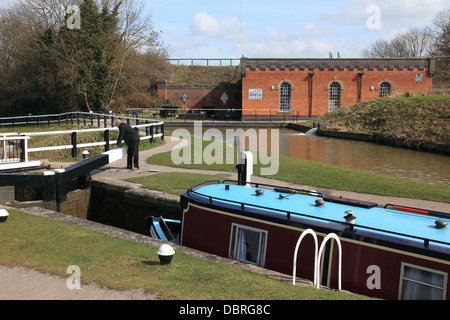 Ein Narrowboat absteigend Foxton sperrt am Grand Union Canal, mit Foxton Kanalmuseum im Hintergrund Stockfoto