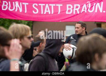 Bad Nenndorf, Deutschland. 3. August 2013. Ein Polizist steht unter einem Gegendemo Banner als Reaktion auf einer Neonazi-Kundgebung in Bad Nenndorf, Deutschland, 3. August 2013. Eine große Gruppe von Menschen vor einer Neonazi-Kundgebung gebildet. Foto: SEBASTIAN KAHNERT/Dpa/Alamy Live News Stockfoto