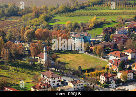 Luftbild auf Kleinstadt zwischen wunderschönen bunten Feldern und Bäumen im Herbst im Piemont, Norditalien. Stockfoto