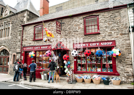 Geschäfte auf Castle Street, einer der Hauptstraßen von Conwy, die parallel zum Meer verläuft. Conwy ist eine historische Festungsstadt am bekanntesten für Conwy Castle, das am südlichen Ende der Castle Street steht. Stockfoto