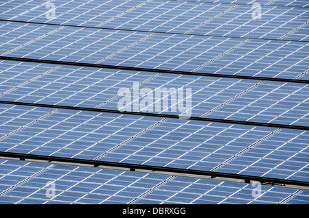 Solar Photovoltaik-Array polykristalline Panels / Reihen von polykristallinen Silizium-Photovoltaik-Panels decken eine Solaranlage im Versorgungsmaßstab unter voller Sonne ab. Die charakteristische blaue Farbe jedes Panels kommt von der kristallinen Struktur des Siliziums; polykristalline Zellen sind billiger herzustellen als monokristalline, aber etwas weniger effizient, wobei sie normalerweise 15 17 % einfallender Sonnenstrahlung in Strom umwandeln. Stockfoto