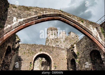 Conwy Castle Archway Conwy Wales / CONWY, Vereinigtes Königreich — Ein Blick durch einen bogenförmigen Steineingang auf Conwy Castle zieht den Blick in das Innere der Festung, das rauhe Steinwerk, das den Innenhof dahinter umrahmt. Erbaut zwischen 1283 und 1287 während der Eroberung von Wales durch Eduard I., wurde die Burg von Meister James of St. George entworfen und gilt weithin als eines der besten Beispiele für Militärarchitektur des späten 13. Jahrhunderts in Europa. Die Festung ist Teil des „Eisernen Ringes“ von Burgen Eduards I. in Nordwales, der die englische Herrschaft in der gesamten Region konsolidieren soll, und wurde zum UNESCO-Weltkulturerbe erklärt Stockfoto