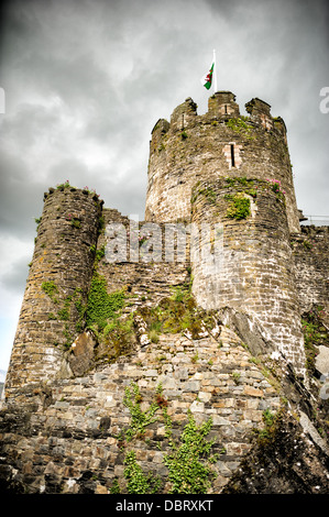 CONWY, Wales – die imposanten Türme und Mauern von Conwy Castle, einer mittelalterlichen Festung aus dem 13. Jahrhundert, erheben sich vor einem bedrohlich bewölkten Himmel in Nordwales, Großbritannien. Dieses UNESCO-Weltkulturerbe, erbaut von König Eduard I., zeigt die einschüchternde Präsenz der mittelalterlichen Militärarchitektur, die steinernen Befestigungen vor der dramatischen Kulisse. Stockfoto