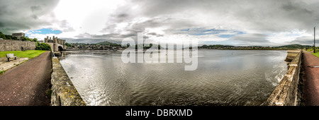 Eine Aussicht auf den Fluss Conwy von Conwy Weg mit dem Schloss auf ganz links der Rahmen und der Stadt am anderen Ufer in Bildmitte. Conwy Castle ist eine mittelalterliche Burg, die von Edward i. im späten 13. Jahrhundert erbaut. Es ist Bestandteil einer ummauerten Stadt Conwy und nimmt einen strategischen Punkt auf dem Fluss Conwy. Es ist als Weltkulturerbe aufgeführt. Stockfoto