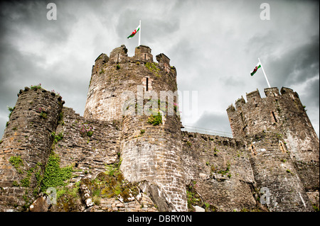 CONWY, Wales – die imposanten Türme und Mauern von Conwy Castle, einer mittelalterlichen Festung aus dem 13. Jahrhundert, erheben sich vor einem bedrohlich bewölkten Himmel in Nordwales, Großbritannien. Dieses UNESCO-Weltkulturerbe, erbaut von König Eduard I., zeigt die einschüchternde Präsenz der mittelalterlichen Militärarchitektur, die steinernen Befestigungen vor der dramatischen Kulisse. Stockfoto