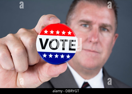 Ein männlicher Wähler hält eine Abstimmung Pin, demokratische Wahlen in den Vereinigten Staaten zu fördern Stockfoto