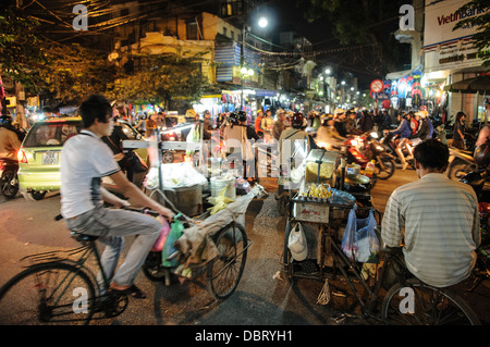 HANOI, Vietnam – der Verkehr mit Fahrrädern und Motorrollern ist nachts in der Altstadt von Hanoi angesiedelt. Stockfoto