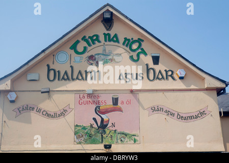 Guinness Tukan Ausgleich Pint auf Schnabel Wandkunst und Zeichen auf Gälisch an Pub Außenseite Spiddal County Galway Irland Stockfoto