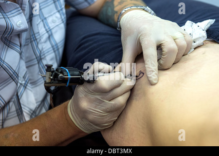 Tattoo-Künstler bei der Arbeit. Stockfoto