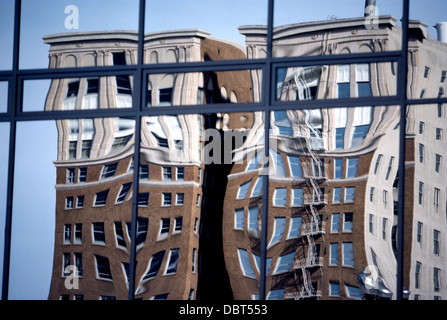 Zwei alte Backsteinbauten in der Innenstadt von Long Beach, Kalifornien, spiegeln sich in der gewellten Glasfenstern einen modernen Büroturm. Stockfoto