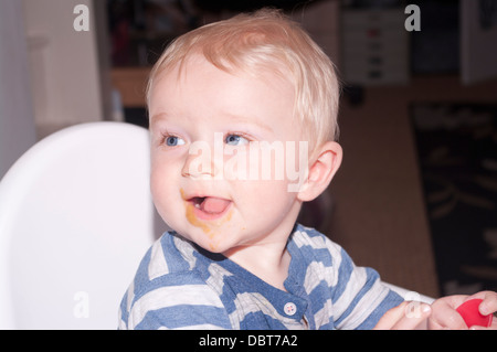 6 Monate altes Baby Boy mit Essen rund um den Mund Stockfoto