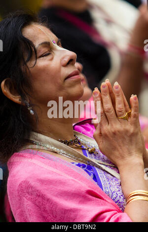 Leicester, UK, 4. August 2013.  Ein Hare-Krishna-Anhänger betet während der Rathayatra Straßenfest in Leicester Stadtzentrum entfernt.   Drei 40ft Streitwagen wurden von Hand zog durch die Stadt, begleitet von Tanz und Musik.  Rathayatra ist eine 5.000 Jahre alte Festival mit Ursprung in Jagannatha Puri in Indien. Bildnachweis: Graham Wilson/Alamy Live-Nachrichten Stockfoto