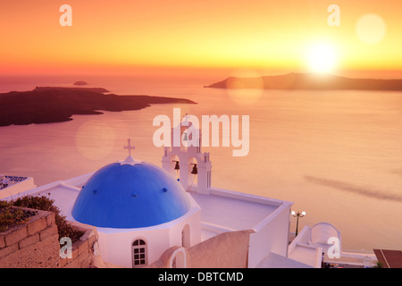 Panoramablick auf einer blauen Kuppel der Kirche St. Spirou in Firostefani auf der Insel Santorini, bei Sonnenuntergang Stockfoto