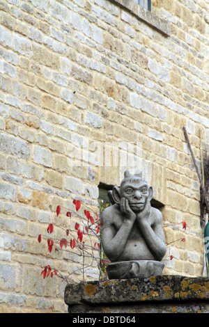 Gargoyle auf einer Mauer sitzend Stockfoto