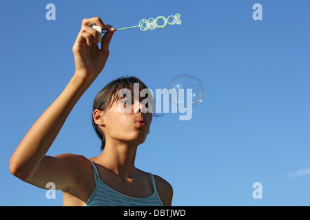 Das hübsche kleine Mädchen bläst Seifenblasen Stockfoto