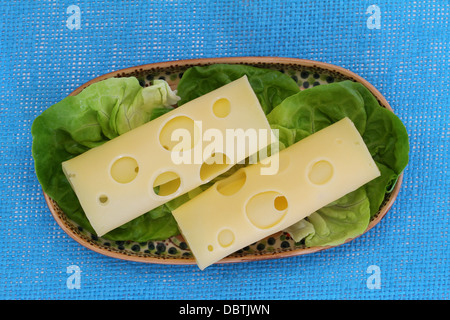 Scheiben von Schweizer Käse auf Salat Blätter Stockfoto