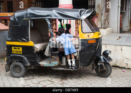 Kleine indische Junge spielt auf Autorikscha verkrüppelt Beinschienen Stockfoto