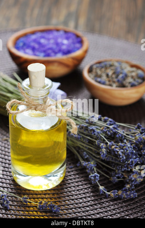 ätherisches Lavendelöl mit frischen Blumen auf hölzernen Hintergrund Stockfoto