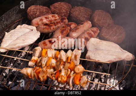 Essen Hamburger Hacksteaks Würstchen Hähnchen und Kebabs Kochen auf eine Bar B Q Stockfoto