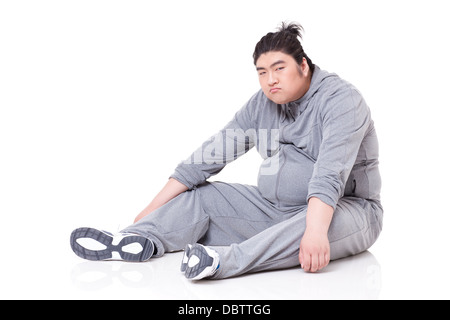 Unglücklich dicker Mann auf dem Boden sitzend Stockfoto
