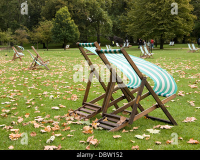 Liegestühle legen leer im kühlen Herbst Wind, der weht über Hyde Park, London. Stockfoto