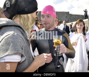 Sänger Ronan Keating, Fernsehmoderatoren Jenny Frost und Jason Bradbury und streng Sterne Pamela Stephenson abgeschlossen haben einen Marathon-Fundraising-schwimmen über die irische See. Unter der Leitung von Olympiasieger Schwimmerin Steve Parry, sie alle berührten landen am Strand nur noch Stockfoto