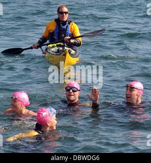 Sänger Ronan Keating, Fernsehmoderatoren Jenny Frost und Jason Bradbury und streng Sterne Pamela Stephenson abgeschlossen haben einen Marathon-Fundraising-schwimmen über die irische See. Unter der Leitung von Olympiasieger Schwimmerin Steve Parry, sie alle berührten landen am Strand nur noch Stockfoto