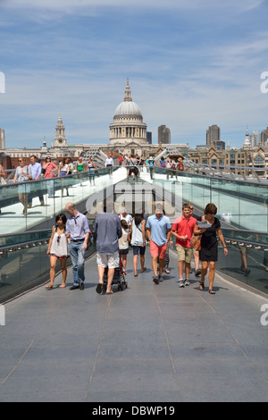 Touristen über die Millennium Brücke mit Blick auf St. Pauls Cathedral hinter.  London, UK. Stockfoto