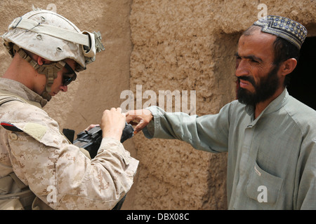 US Marine Corps Lance Cpl. Großbritannien Morris mit Fox Company sammelt Informationen von einem afghanischen Mann mit einer sicheren elektronischen Einschreibung Baukastensystem während einer Patrouille 29. Juli 2013 in Washir, Provinz Helmand, Afghanistan. Stockfoto