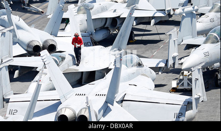 Ein US-Marine Aviation Ordnanceman führt Korrosion Prävention Wartungsarbeiten an einer F/A-18E Super Hornet Flugzeuge an Bord des Flugzeugträgers USS Harry S. Truman 2. August 2013 in den Atlantischen Ozean. Stockfoto