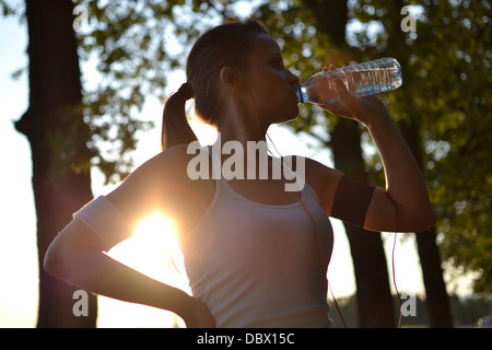 junge Frau Trinkwasser während ihres Trainings Stockfoto