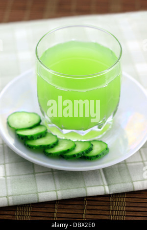 Gurkensaft neben Gurkenscheiben Stockfoto
