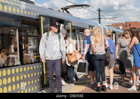 Alltägliche Szene der Passagiere auf überfüllten Plattform mit Menschen an Bord eines Metrolink tram an Deansgate-Castlefield Bahnhof in Manchester City. England Großbritannien Stockfoto