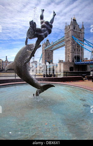 Mädchen mit A Delphinbrunnen und der Tower Bridge im Hintergrund, London, UK Stockfoto