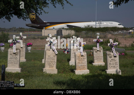 McAllen, Texas - La Piedad Friedhof, neben einem UPS Fracht Jet warten am Flughafen McAllen-Miller. Stockfoto