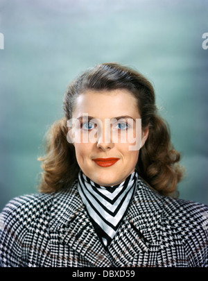 1940S 1950S PORTRAIT LÄCHELNDE FRAU TRAGEN HOUNDS ZAHN TWEED MANTEL GESTREIFTEN SCHAL BLICK IN DIE KAMERA Stockfoto