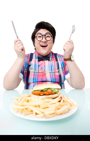 Junger Mann essen Fastfood mit Übergewicht Stockfoto